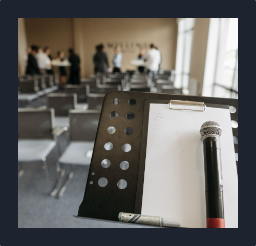 Mikrofon na mównicy w sali konferencyjnej.